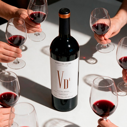 Botella Magnum de vino tinto compartida entre varias copas en la mesa