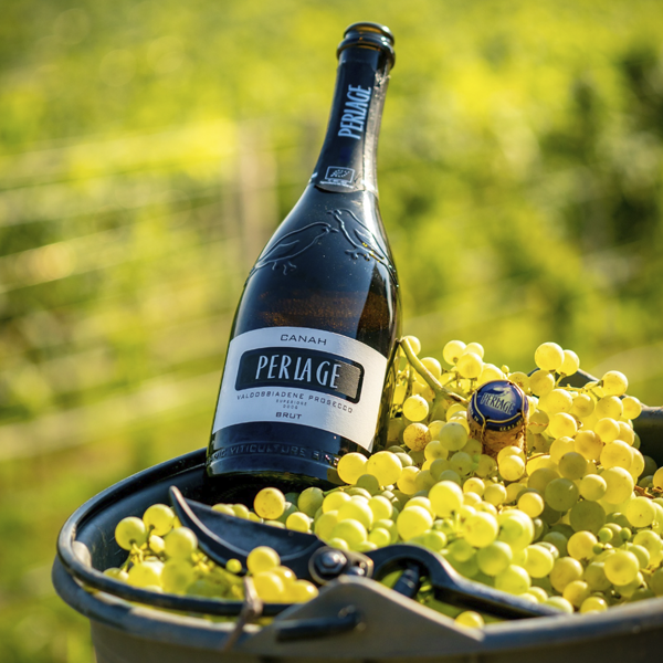 Botella de Canah Brut de Perlage servida al aire libre junto a un aperitivo.